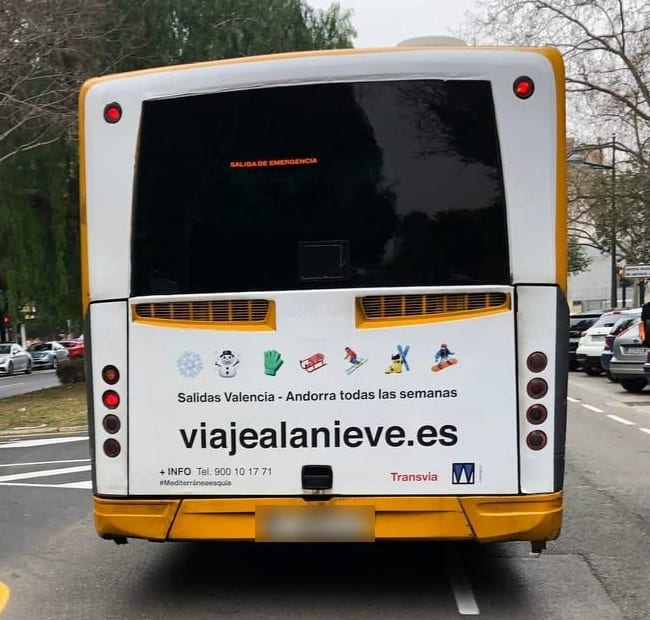 Parte trasera de un autobús de Transvia con publicidad de viajealanieve.es: salidas Valencia - Andorra todas las semanas