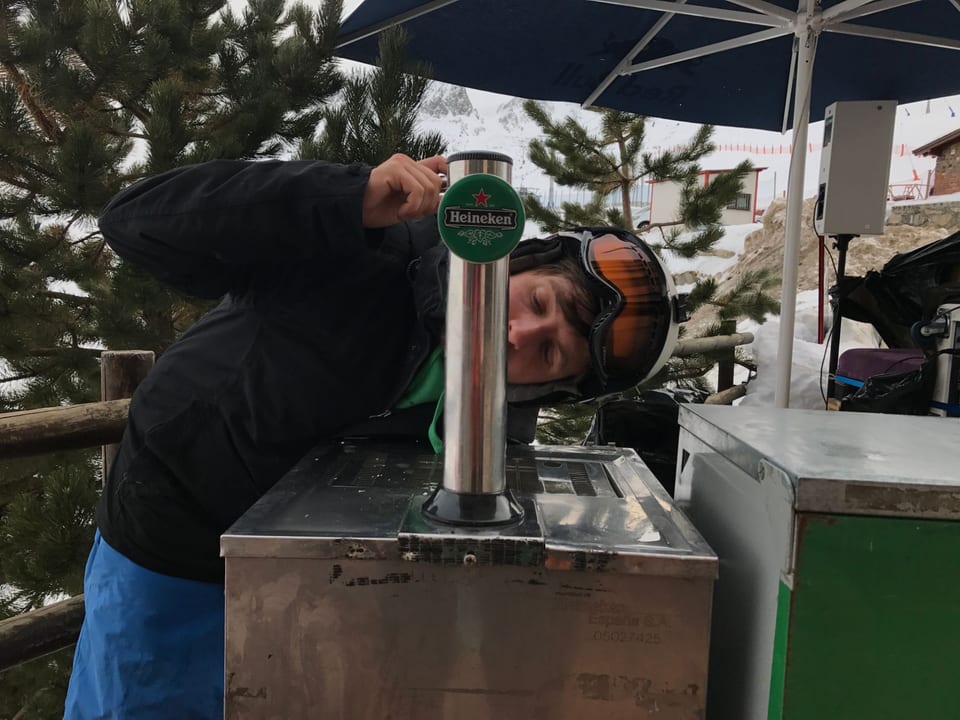 Vicent Ferrer con casco y gafas de esquí, mirando de cerca el grifo de cerveza Heineken mientras prepara la SnowParty en las pistas de Pas de la Casa