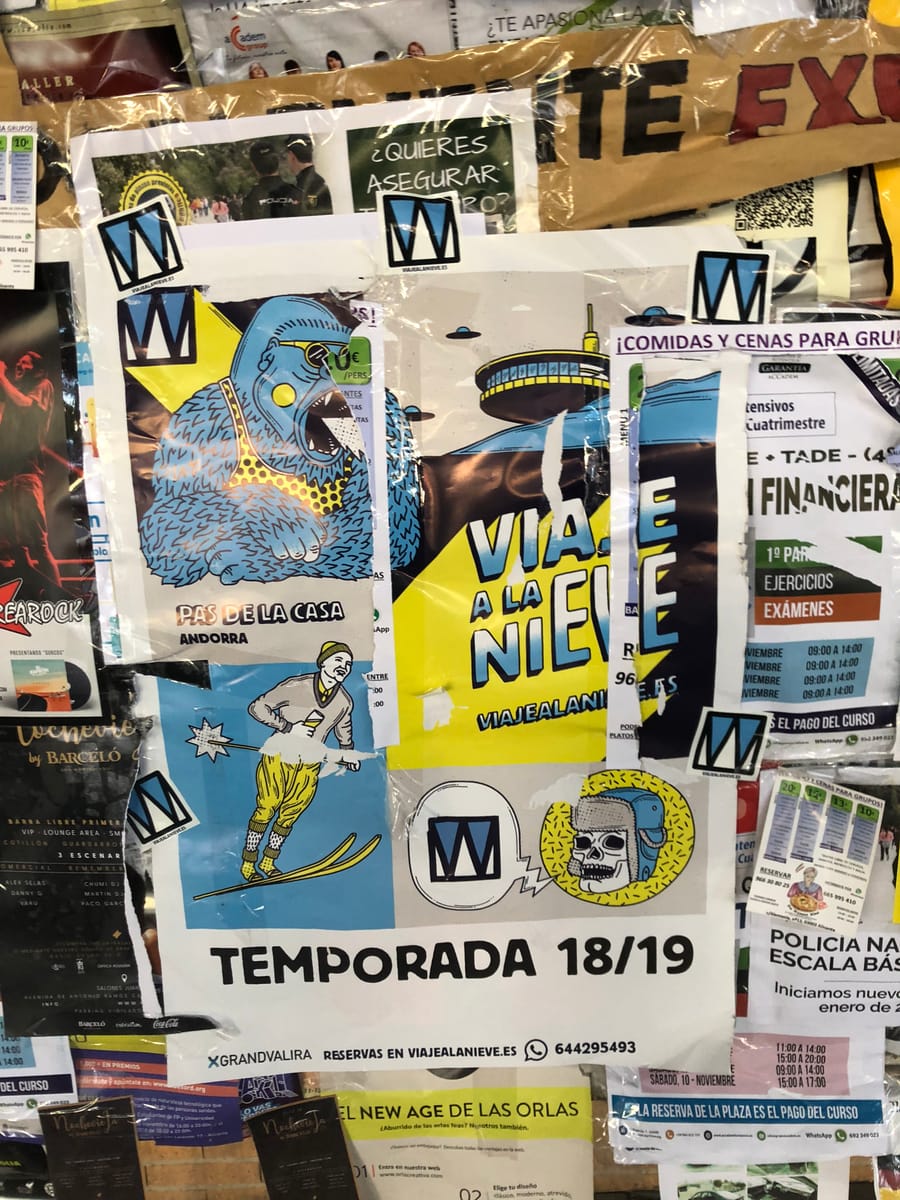 Muro de una facultad lleno de carteles de viajealanieve.es de la temporada 2018-19 y pegatinas con el logo de la W